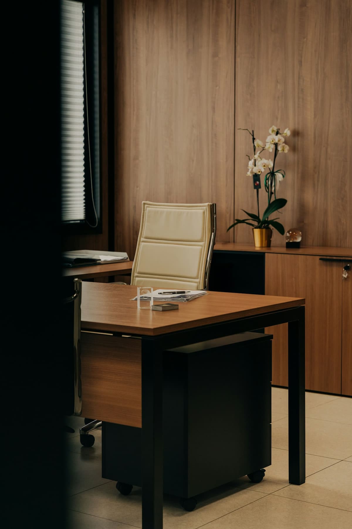 Sala corporativa com marcenaria planejada em madeira e mesa executiva